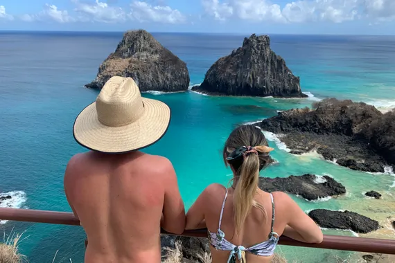 Casal apreciando a paisagem no Mirante com vista para Baia dos Porcos e Morro dos Dois Irmãos